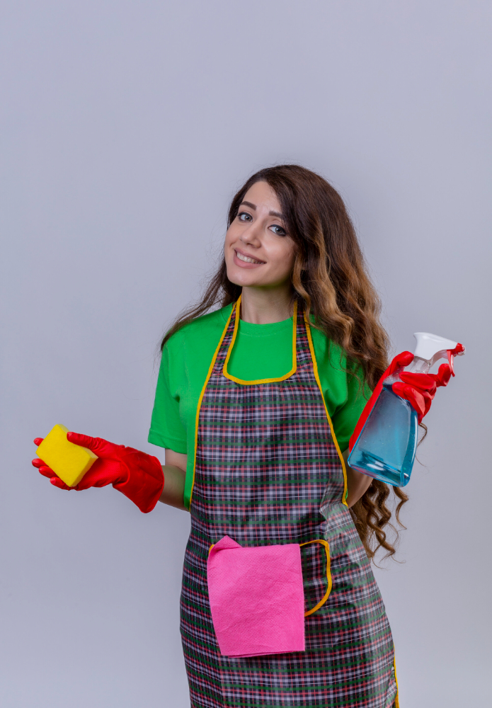 A woman in an apron holds a cleaning product, representing Kainos Cleaning services in Orlando, Florida for residential and commercial cleaning.