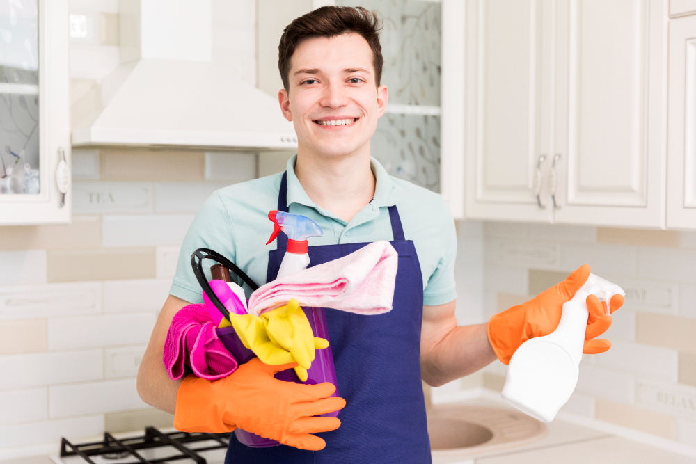 A man in an apron holds a cleaning product, representing Kainos Cleaning's regular cleaning services in Orlando, FL. Adjust this image on service page regular cleaning